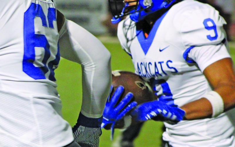 Sentinel Photo/Mike Reddell Junior wide receiver Isaac Stinson (9) was the Blackcats leading receiver with 117 yards on three catches that included a 57-yard touchdown pass reception. Above, Stinson follows the blocking of  sophomore Malcolm Perez (62).