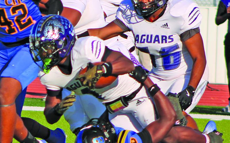 Sentinel Photo/Mike Reddell Trevell Wells (18) topples the Jaguar quarterback from below.