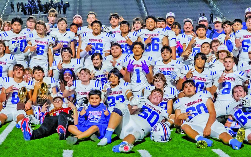 Courtesy of Migas Productions The Tidehaven Tigers show off their bi-district trophy (center) after defeating Comfort Thursday, Nov. 13, in Seguin.