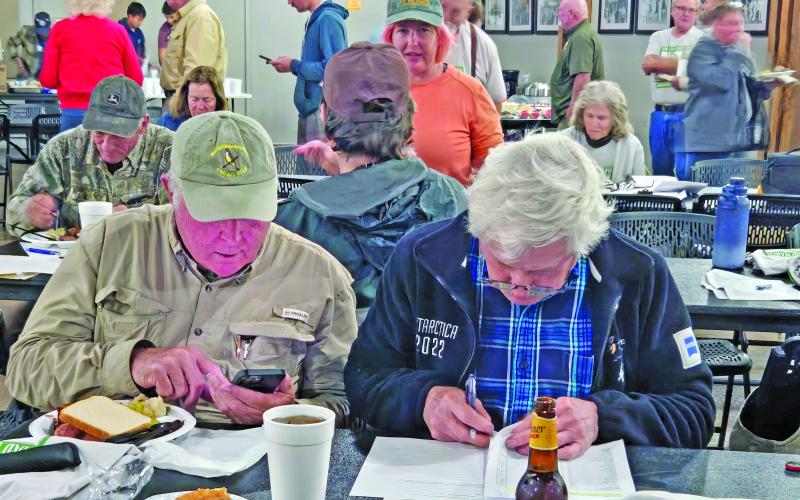 Sentinel Photo/Jessica Shepard Between bites of dinner, birders compare notes to finalize their respective section’s species tallies as part of the 126th Annual Audubon Christmas Bird Count on Monday night.