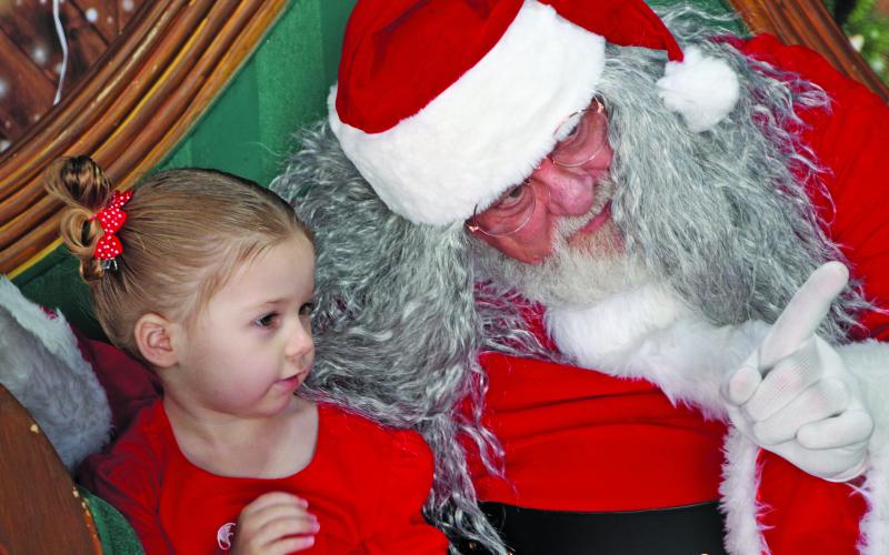 Sentinel Photo/Mike Reddell Santa has the attention of this little girl as he explains something - maybe his many Christmas stops - during last week’s Santa’s Flyin Storytime at Bay City Regional Airport. It was presented by Bay City Public Library, Bay City Regional Airport and Van Vleck High School Theater.