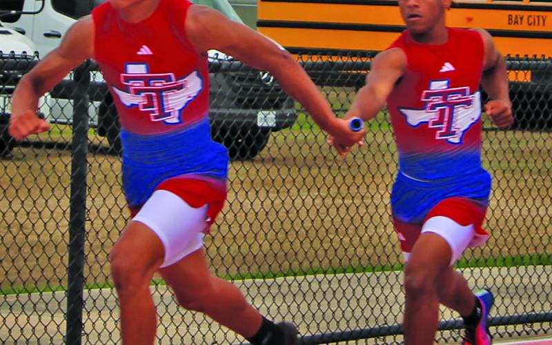 Sentinel Photo/Mike Reddell Tidehaven’s Jullian Stockton, left, takes the baton from Jacob Singletary during a relay at the Van Vleck meet last week.