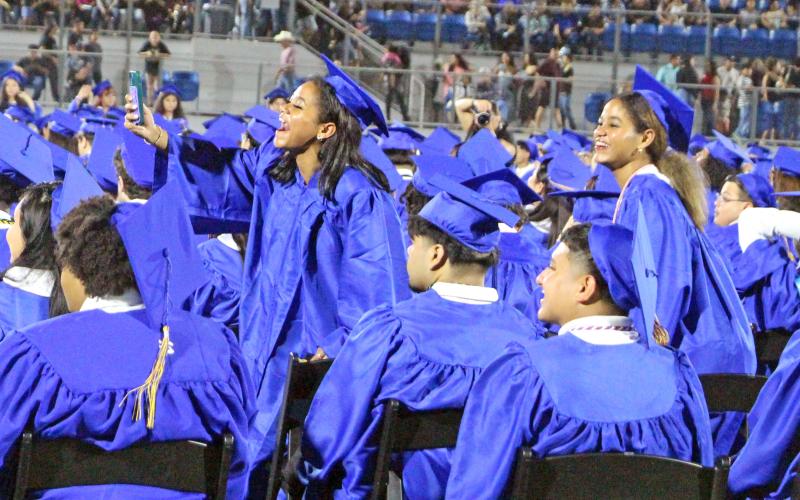 Sentinel Photo/Jessica Shepard Several Bay City High School seniors showed support for their fellow graduates during their graduation ceremony on May 22. The graduates above cheered on their peers while some took pictures and video clips to share on social media and with each other.