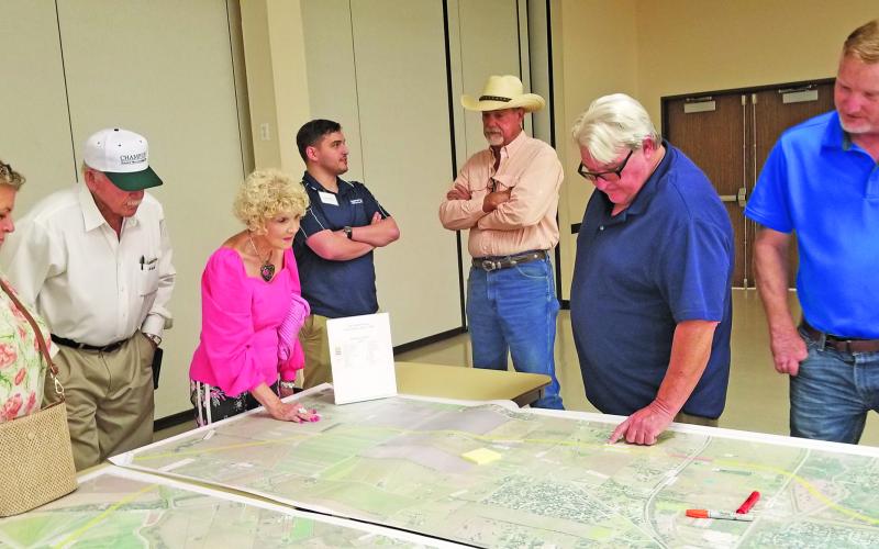 Sentinel Photo/Mike Reddell People gather around a TxDOT map of a possible route relief at a recent information session at the Bay City Civic Center.