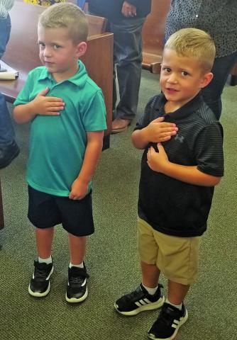 Commissioner Mike Estlinbaum’s grandsons, Connor (left) and Luke, lead the court’s pledges. Sentinel Photo/Mike Reddell