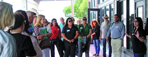 Sentinel Photo/Jessica Shepard Bay City Main Street Program Director Tina Isreal, right, explains how almost every downtown business has used the program’s façade grants to beautiful or renovate their building’s exteriors. Israel’s downtown walking tour was the capstone of the Houston-Galveston Area Council’s “Downtown Roundtable” July 25.