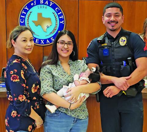 Sentinel Photo/Jessica Shepard Bay City PD's Corporal Jose Soto received an award and recognition for performing life-saving CPR on infant Emery Lazo at the City Council on Tuesday, April 9. Soto, right is joined by Emery Lazo and her family at the meeting. 