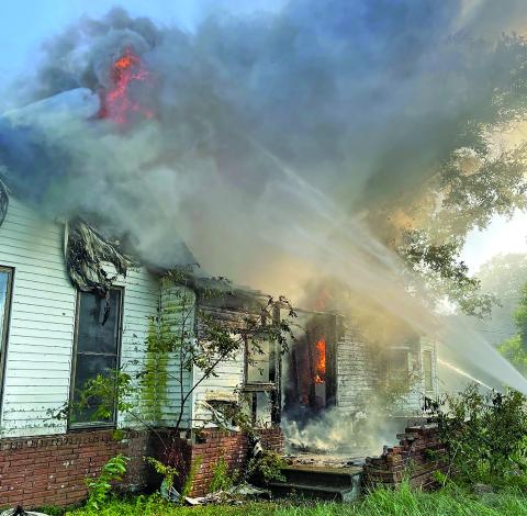 Dan Shook photo Firefighters keep a steady stream of water on a fire at vacant house at 155 Janise.