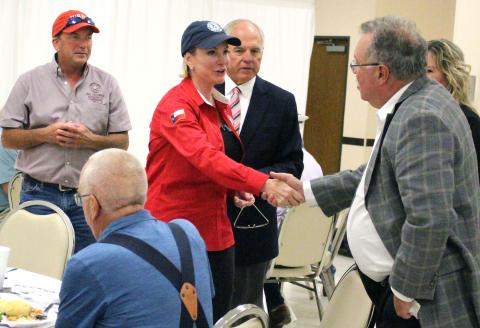 Sentinel Photo/Jessica Shepard Land Commissioner Dawn Buckingham shakes hands with MCEDC Executive Director Mike Ferdinand, while Precinct 2 Commissioner Mike Estlinbaum, left, and Chamber President Mitch Thames look on. 