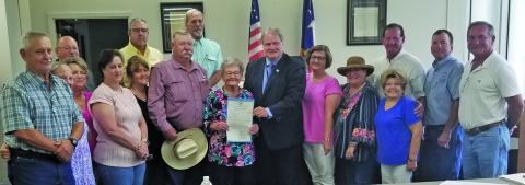 Sentinel Photo/Mike Reddell Commissioners Court proclaimed Monday, July 15, as Helen Feldhousen Day in Blessing. Miss Helen, center with proclamation from County Judge Bobby Seiferman, was joined by family and friends at the court session. She started as kitchen support in 1969 and became sole proprietor in 1977 and continued through 2024.
