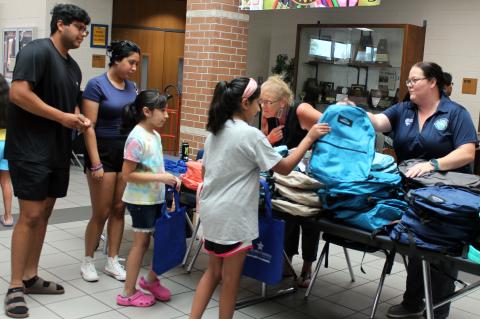 Sentinel Photo/Jessica Shepard Volunteers passed out backpacks from bulging stacks of different styles and colors at the BCISD Back to School Bash last week.