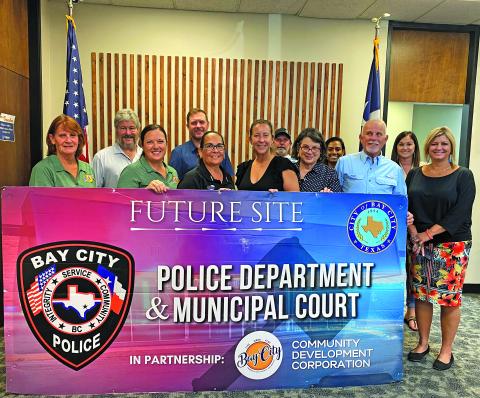 Sentinel Photo/Jessica Shepard Bay City Police Chief Christella Rodriguez and Bay City Community Development Corporation Executive Director Jessica Russell posed with the BCCDC board to celebrate the community partnership between the entities Monday afternoon. The partnership will help fund the creation of a new public safety facility.