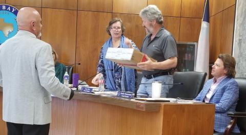 Sentinel Photo/Mike Reddell Bay City Police Narcotics Division Head Sgt. Joe Bruno, left, hands a shipment box with illegal drugs to, from left, Mayor Pro Tem Becca Sitz, and Councilmen Jim Folse and Bradley Westmoreland at a recent council meeting.