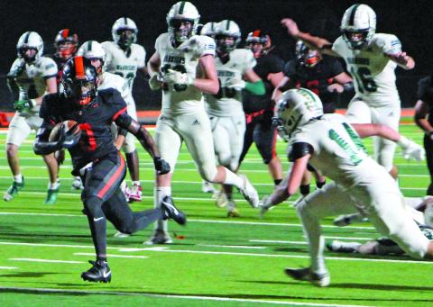 Sentinel Photo/Jessica Shepard Van Vleck running back Corey Austin (0) outruns Woodlands defenders in the Leopards homecoming game last Friday.