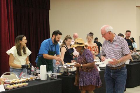 Sentinel photo/Jessica Shepard Donnye Stone, center with hat, shares the good-natured banter with one of the cooking teams at the Gourmet Guys fundraiser for the Matagorda County  Museum Saturday, Sept. 28.