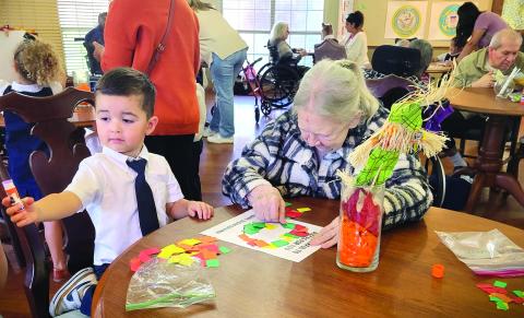 Holy Cross Catholic School photo During Community Helpers Week, Holy Cross Catholic School's PreK-3 and PreK-4 students visited the Colonial Living Nursing and Rehabilitation Center as part of their giving back to the community. The students entertained with the song, "Here I Am To Worship." They also colored with residents and gave them their artwork. 