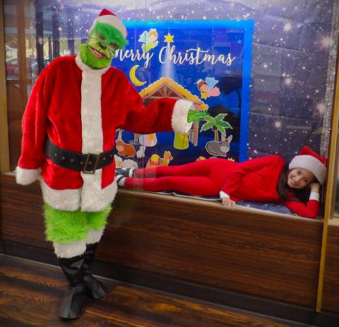 Holy Cross photo Holy Cross Catholic School had  an 'Elf on a Shelf'  Wednesday, Dec 11. Some students walked by unaware, while others giggled with joy. On Grinch Day, Dec. 12, she was found behind glass in the school's display cabinet by the Grinch himself.  