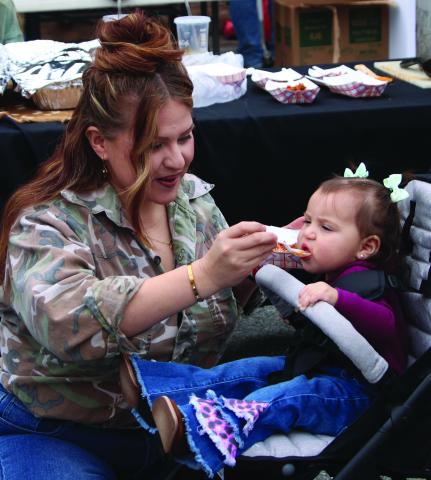 A mother offers her child a small taste of Camofest cuisine downtown Bay City Satur- day, Jan. 25. The annual event drew at least a dozen food vendors featuring a vast array of different tastes. Sentinel Photo/Mike Reddell