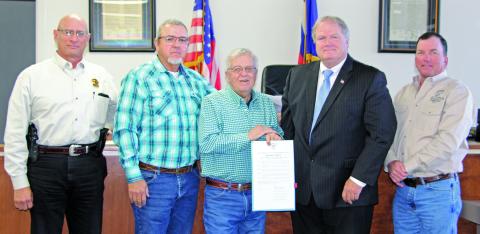 Sentinel Photo/Jessica Shepard Commissioners approved a resolution honoring outgoing Sheriff Frank “Skipper” Osborne, center, for his service to the county Monday morning. With Osborne are, from left: Sheriff Rick DeLeon, Precinct 4 Commissioner Bubba Frick, County Judge Bobby Seiferman, and Precinct 2 Commissioner Mike Estlinbaum.