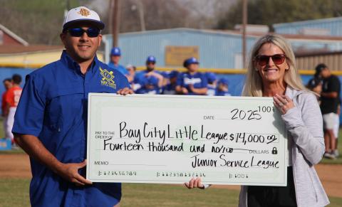 Sentinel Photo/Jessica Shepard Bay City Little League President James Cadenas, left, accepts a $14,000 donation from the Junior Service League of Bay City Saturday, March 15.