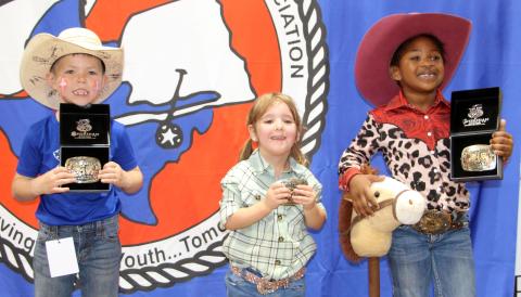 Sentinel photo by Jessica Shepard Three age division buckle winners were chosen for Matagorda County Fair & Livestock Association's first "Little Rodeo" last week. Banks Busby, Ellison Russell, and Londyn Gatson won buckles in the 6-7, 2-3, and 4-5 age divisions respectively. Each child had to retrieve a ribbon tied around a lamb's tail and race their stick horses in the competition.