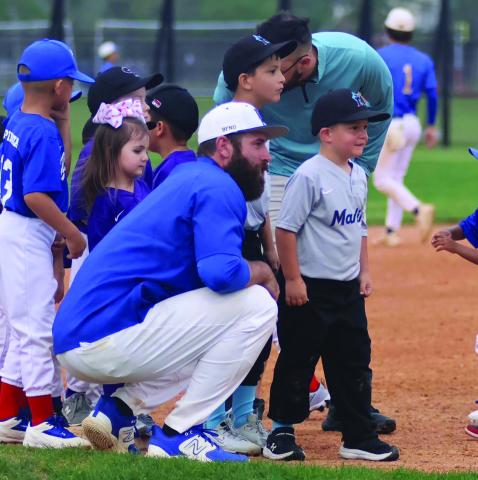 BCISD photo Bay City High School Baseball Coach Jared Hoelscher talks to a Little Leaguer when the Blackcats hosted Little League at a recent game.
