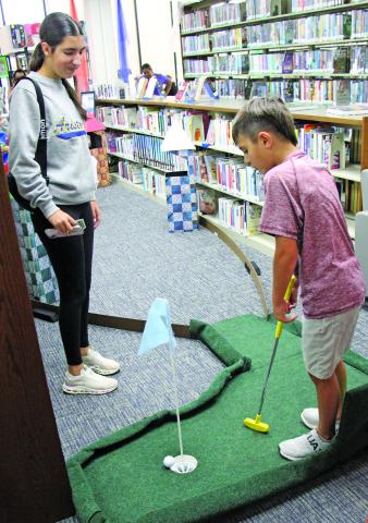 Sentinel Photos/Jessica Shepard Friends of the Bay City Public Library brought back their "Library Mini Golf" fundraiser on Tuesday, July 22. Children and adults of all ages took shots through winding fairways and obstacles ranging from stuffed animals to angled tracks and ramps and a vibrant fairway finish line.