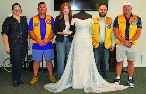 Sentinel Photo/Jessica Shepard Bay City Lions Club members pose with this year’s Rice Festival Queen dress, sponsored by New Beginnings Bridal & Prom in El Campo on Sept. 5. Pictured from left are: Lions Club Rice Festival Queen Pageant Director Rachel Ricks, Lions Club President Mike Griffith, New Beginnings Bridal & Prom representative Kasey Burns, Lions Club Rice Festival Queen Pageant Chairman Ryan Ricks, and Lions Club Rice Festival Chairman Trent Tinnin. 