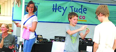 Sentinel Photo/Jessica Shepard Customers braved ominous skies to shop at Downtown Bay City Market Day on Saturday, Nov. 22. Vendors showed off a variety of potential Christmas gifts, like one youngster, center, showing off a 3D-printed fidget toy. 