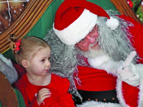 Sentinel Photo/Mike Reddell Santa has the attention of this little girl as he explains something - maybe his many Christmas stops - during last week’s Santa’s Flyin Storytime at Bay City Regional Airport. It was presented by Bay City Public Library, Bay City Regional Airport and Van Vleck High School Theater.