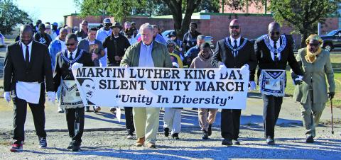 Sentinel Photo/Jessica Shepard Almost 80 citizens participated in the annual "Martin Luther King, Jr. Silent Unity March"  on Monday, Jan. 19.  Attendees walked roughly five blocks to the Hilliard High Alumni Building while holding a variety of posters and photographs depicting King. Elected officials present included Matagorda County Judge Bobby Seiferman, Bay City Mayor Robert Nelson, and Councilman Ben Flores.