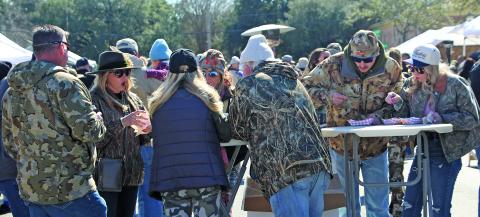 Sentinel Photo/Jessica Shepard Camofest patrons ignore the brisk winds and temperatures Saturday, Jan. 31, to enjoy the 10th annual event’s "Food Camp" with locally sourced wild game, including deer chili, alongside various fish and fowl dishes. The event also featured Texas wines, beers, and vendor-sold food items. This group of diners also exhibited the camo wear that’s part of the event’s theme.