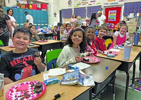 Contributed photo The Second Grade at Holy Cross Catholic School takes a moment to smile between their cookies and goodies.