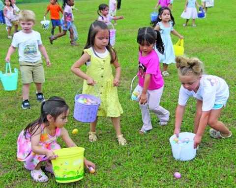 Sentinel Photo/Jessica Shepard These little girls seem to have an area selected to load up and fill their Easter baskets with eggs during Bay City Parks & Recreation Department's "Annual Easter Egg-Stravaganza" in LeTulle Park on Friday, April 3..