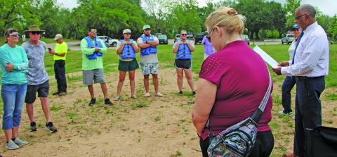 Sentinel Photo/Mike Reddell Kelly Penewitt, above, joins Mayor Robert Nelson as he reads the city’s Water Safety Month Proclamation at the Saturday Rally on the River 2026 to the participating paddlers. The event marked the official opening of the newest TPWD Paddling Trail section. Paddlers, below, prepare to launch their craft at the Riverside Park boat ramp for the 7-mile journey.