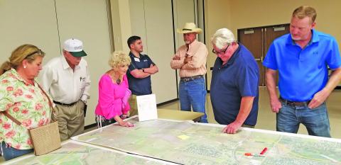 Sentinel Photo/Mike Reddell People gather around a TxDOT map of a possible route relief at a recent information session at the Bay City Civic Center. 