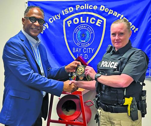 Photo courtesy of Bay City ISD Bay City ISD Police Chief L.C. Cunningham present’s the lieutenant badge to Heather Lewis.