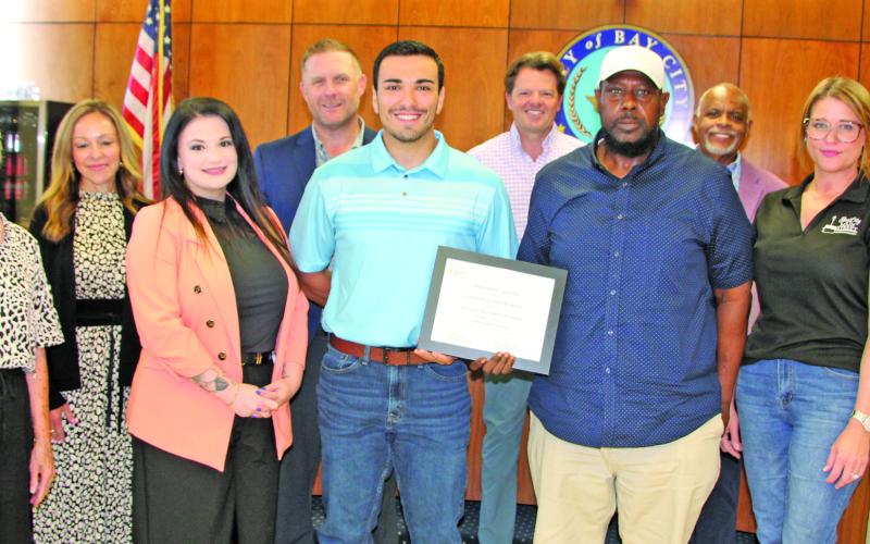 Sentinel Photo/Mike Reddell City Council joins Main Street board members in showing off a plaque recognizing Bay City Main Street as an Accredited Main Street America program.