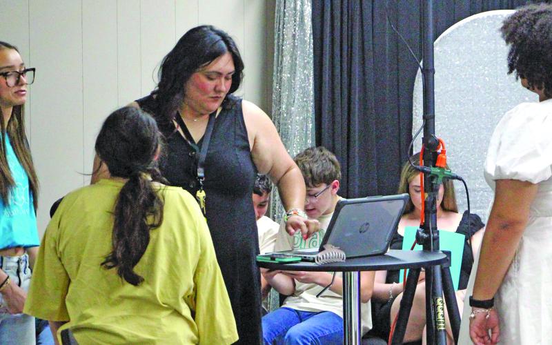 Sentinel Photo/Jessica Shepard Bravo &amp; Co. Youth Theater owner and director Victoria Mitchell, center, multitasks during sound and lighting check while preparing for the academy’s grand opening ceremony Monday, July 6.