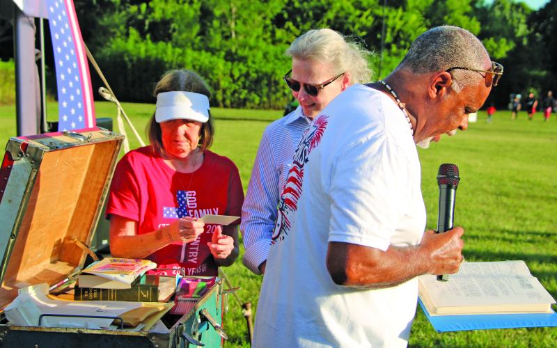 Sentinel Photo/Mike Reddell Mayor Robert Nelson reads from a document that was in the Bay City 1976 time capsule that was opened Saturday, July 4, during Independence Day events at LeTulle Park. As he reads, Matagorda County Museum Archivist Jennifer Bishop, left, and Museum Director Cynthia Armstrong continue to examine the time capsule’s contents.