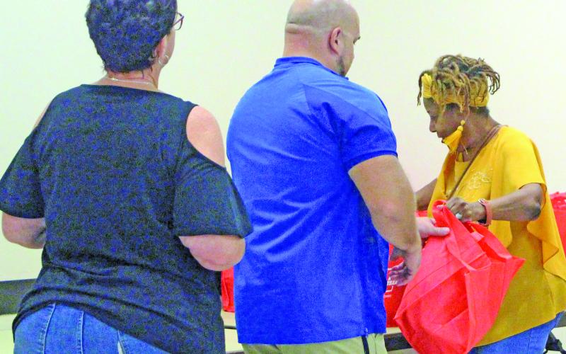 Sentinel Photo/Jessica Shepard Bay City Chamber of Commerce &amp; Agriculture Education Committee volunteer and retired Bay City ISD staff member Donnye Stone, right, hands out goody bags to BCISD’s newest teachers at the annual “New Teacher Breakfast” on Aug. 6.