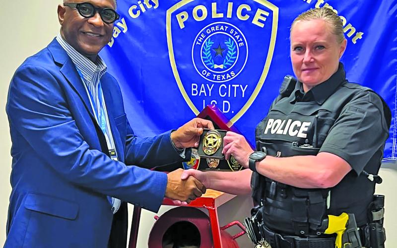 Photo courtesy of Bay City ISD Bay City ISD Police Chief L.C. Cunningham present’s the lieutenant badge to Heather Lewis.