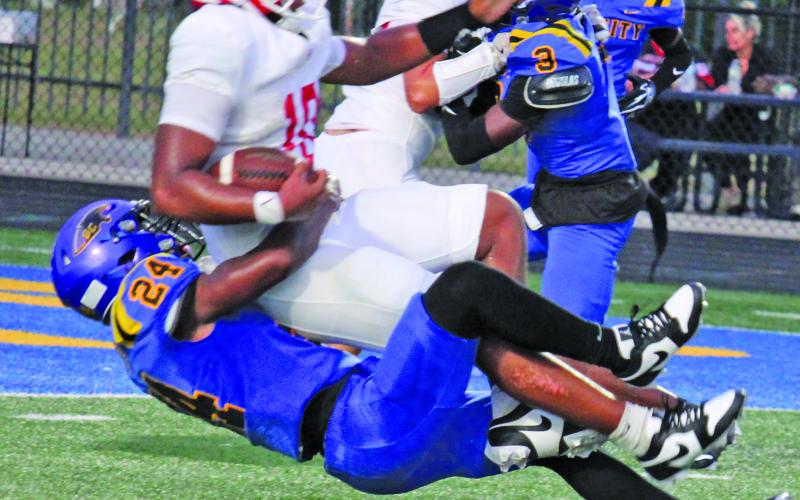 Sentinel Photo/Mike Reddell  Above right, senior linebacker Curtlande Woods (24) brings down a Columbus running back.