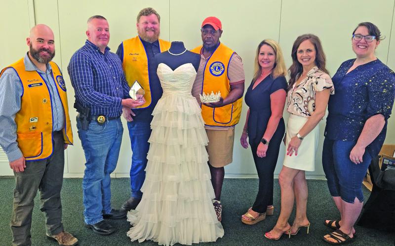 Sentinel Photo/Jessica Shepard Bay City Lions Club members pose with this year's Rice Festival Queen Pageant dress. From left are: Pageant Chairman Ryan Ricks, Festival Chairman Chris Hadash, Club President Chad Craft, and Cory McCray are joined by Green Bros. Jewelers representatives Erin Stone and Amanda Pitard with Pageant Director Rachel Ricks on Aug. 28. The dress and tiara are from El Campo's "New Beginnings Bridal &amp; Prom" while Green Brothers provides the Queen's jewelry.