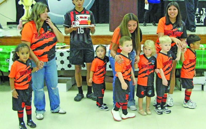 Sentinel Photo/Jessica Shepard Bay City Youth Soccer Club's "Opening Ceremony &amp; Cake Auction" featured over 40 cakes and teams on deck to kick off the fall season on Sept. 8. Seen here are the "Mighty Blasters" attempting to incite higher bids from the crowd.