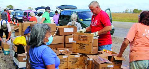 Sentinel photo/Mike Reddell Harvest House distributed 32,335 pounds of food - enough for 400 Matagorda County residents - from the O.H. Herman building Thursday, Nov. 11. Organizer Willie Rollins estimated a line of cars for the distribution was about a mile long. He said 25 volunteers helped with the distribution.