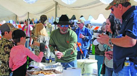 Sentinel photo/Jessica Shepard Serve Outdoors Matagorda Bay Chapter Member Clint Hewitt, center, hands out samples of fried alligator seasoned with Cajun spices and a dash of special sauce during the 6th Annual Camofest event Saturday, Jan. 29. The Serve Outdoors cooking teams also featured fried Oreos, fried Twinkies, daiquiris, and sausage.