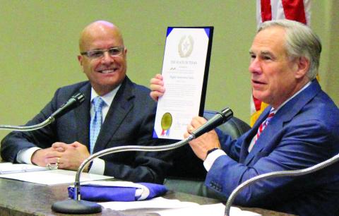 Sentinel photo/Jessica Shepard HIF Global CEO Renato Pereira (left) looks on approvingly as Gov. Greg Abbott presents a state proclamation recognizing HIF’s selection of Matagorda County for the nation’s first eFuel plant and a Texas flag flown over the capitol.