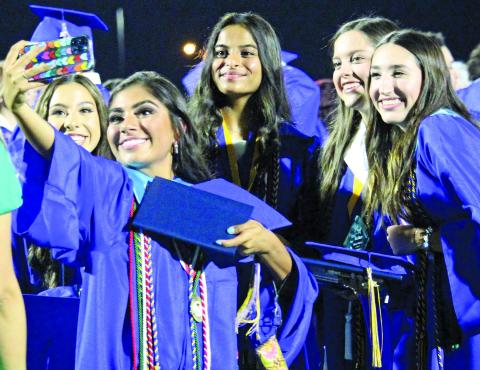 Sentinel photo/Jessica Shepard A handful of Bay City High School Class of 2022 graduates gather around for a little selfie action after their ceremony ended Friday, May 27