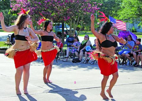 Sentinel photo/Jessica Shepard This trio of Hiti Mahana Polynesia dancers showed off their traditional dancing skills as part of the Bay City Public Library's "Community Luau" event, Thursday, June 23. Hiti Mahana Polynesia also taught audience volunteers several dance moves and provided a variety of songs to entertain the crowd.